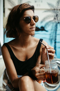 Portrait of a young woman drinking glass