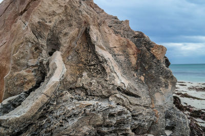 Scenic view of cliff by sea against sky