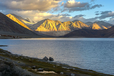 Scenic view of lake by mountains against sky