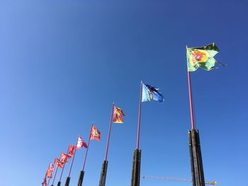 Low angle view of flags flag against clear blue sky