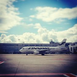 Airplane on airport runway against sky