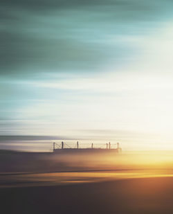 Scenic view of a soccer stadium against sky during sunrise in a foggy morning