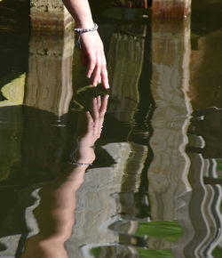 Low section of woman with reflection in water