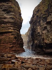 Rock formations by sea against sky