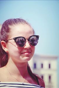 Portrait of woman wearing sunglasses against sky