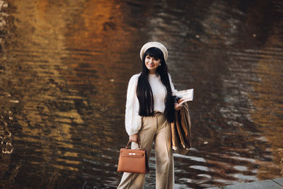 Portrait of woman standing against the wall