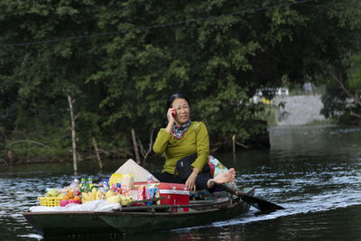 Woman smiling while standing on river against plants