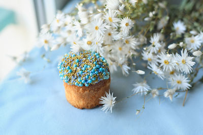 Orthodox easter cake decorated with beads and daisies in the background