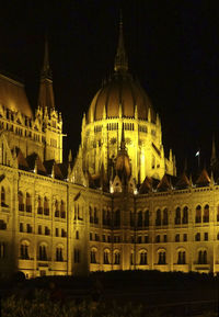 Illuminated building against sky at night in city