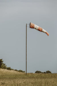 Wind turbines on field against clear sky