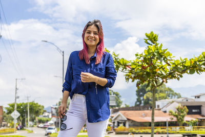 Young woman standing against sky