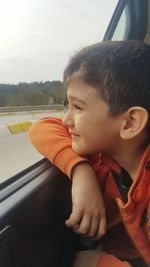 Cute smiling boy in looking through car window