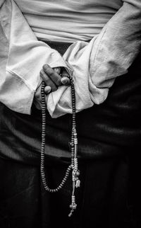 Rear view of man holding beads