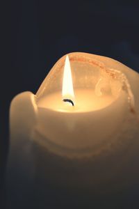 Close-up of lit candle in dark room