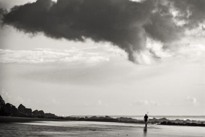 Man standing on beach against sky