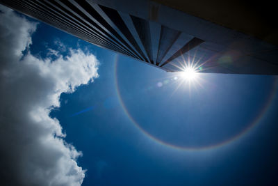 Low angle view of sunlight streaming through clouds