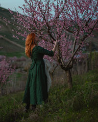 Rear view of woman standing in forest