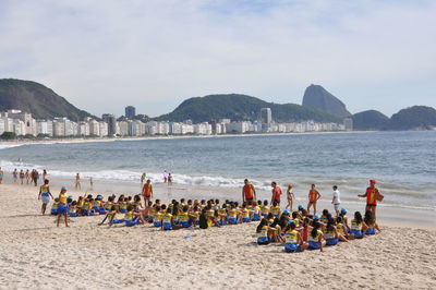 People at beach against sky