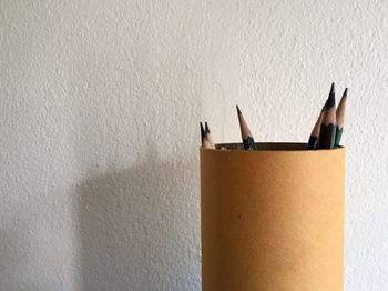 Close-up of pencil on table against wall