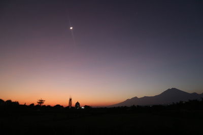 Silhouette landscape against sky at night