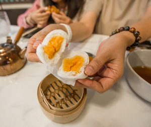 Hand with steamed buns with cream