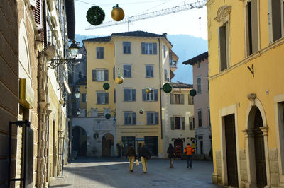 People walking in city against sky