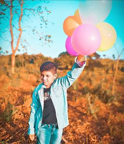 Full length of a man holding colorful balloons