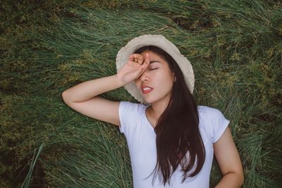 Beautiful young woman with eyes closed on field