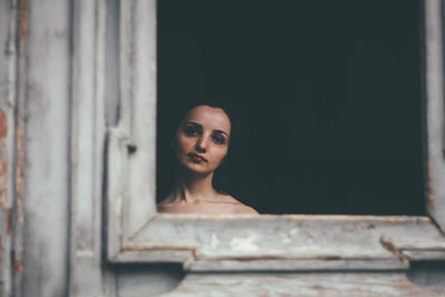 Portrait of woman against window
