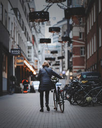 Rear view of woman walking on street in city