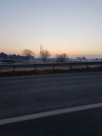 View of road against clear sky during sunset