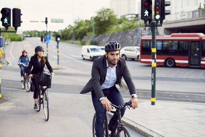 People cycling on street in city