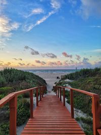 Pier over sea against sky during sunset