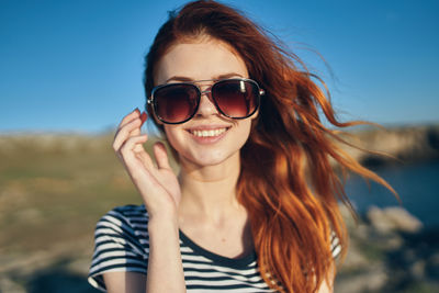 Portrait of smiling young woman wearing sunglasses