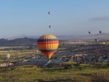 Hot air balloons flying over landscape