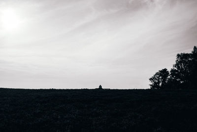 Silhouette of person on field against sky