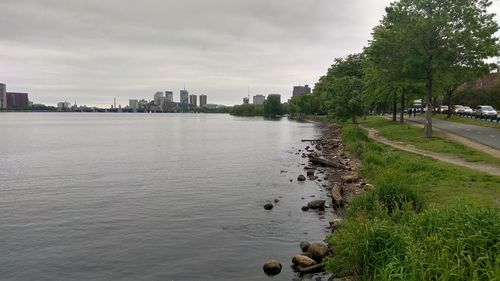 Scenic view of river by buildings against sky
