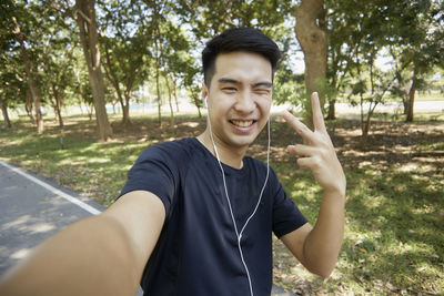 Portrait of smiling young man standing on mobile phone