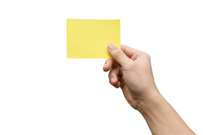 Midsection of person holding paper against white background