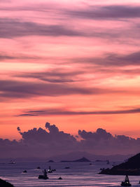 Scenic view of sea against dramatic sky during sunset