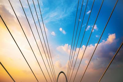 Low angle view of cables against sky during sunset