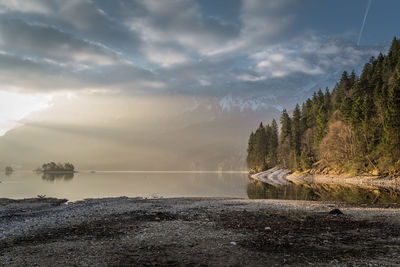 Scenic view of lake and mountains against cloudy sky