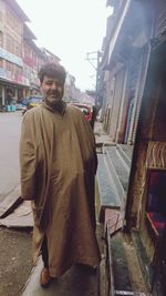 Portrait of young man standing on street in city