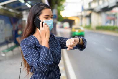 Young woman using mobile phone on street