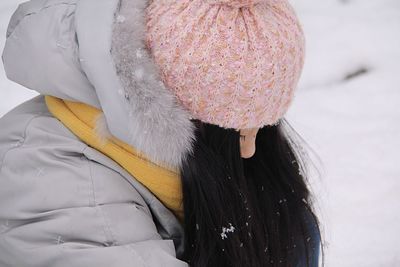 Woman wearing warm clothing enjoying snowfall