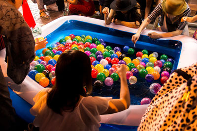 High angle view of people playing with colorful balloons in wading pool