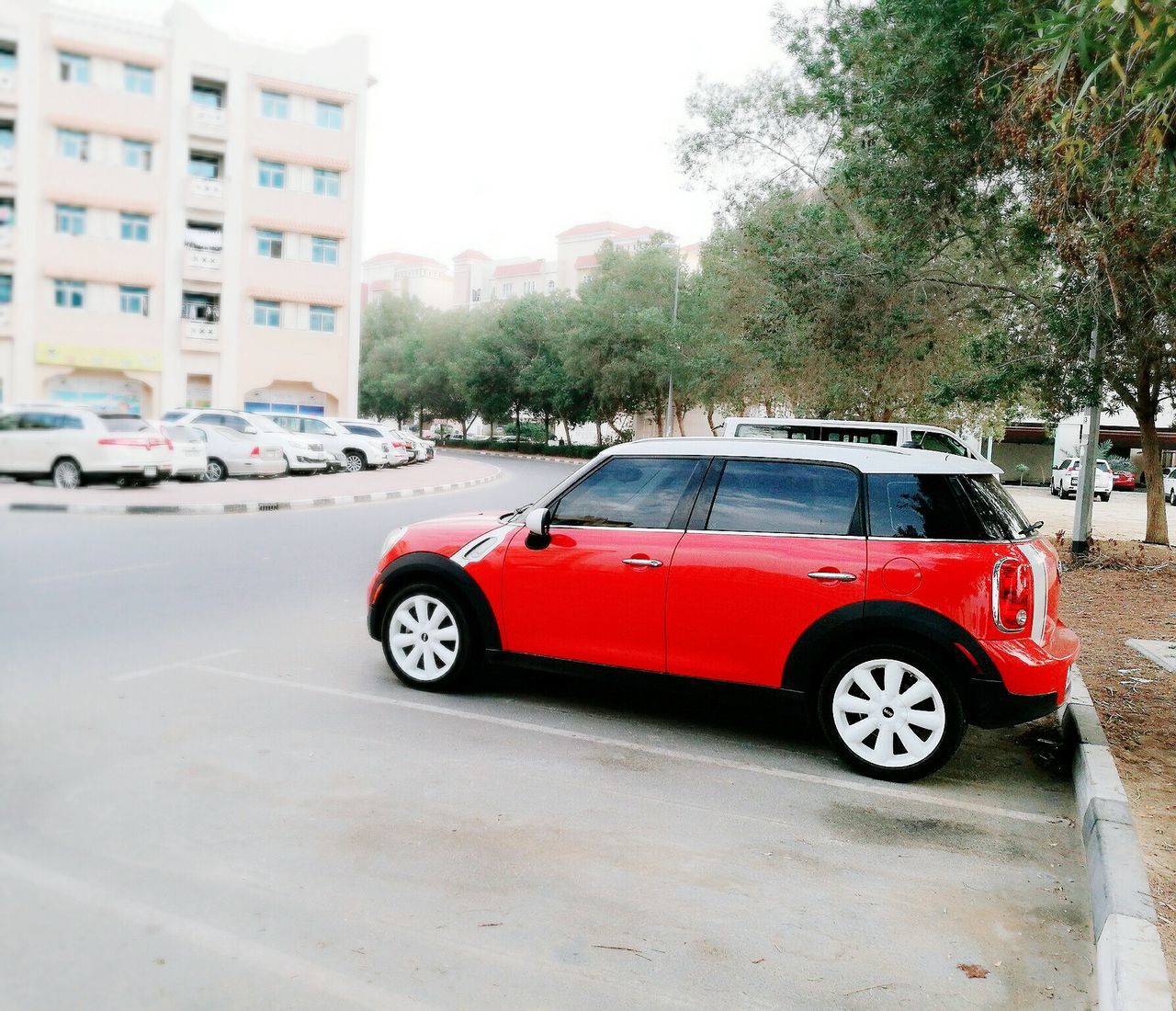 car, city, red, transportation, city street, mode of transport, city life, building exterior, built structure, land vehicle, architecture, road, outdoors, day, nature, no people, sky