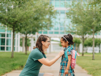 Young millennial mother sending daughter off back to school