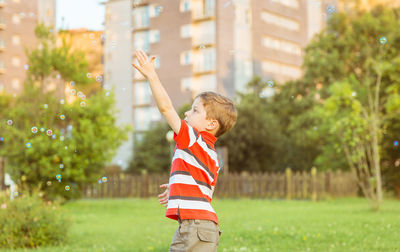 Full length of a boy standing by tree