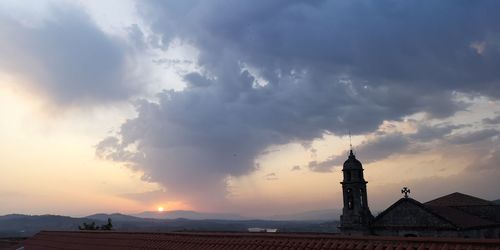 Tower of building against cloudy sky